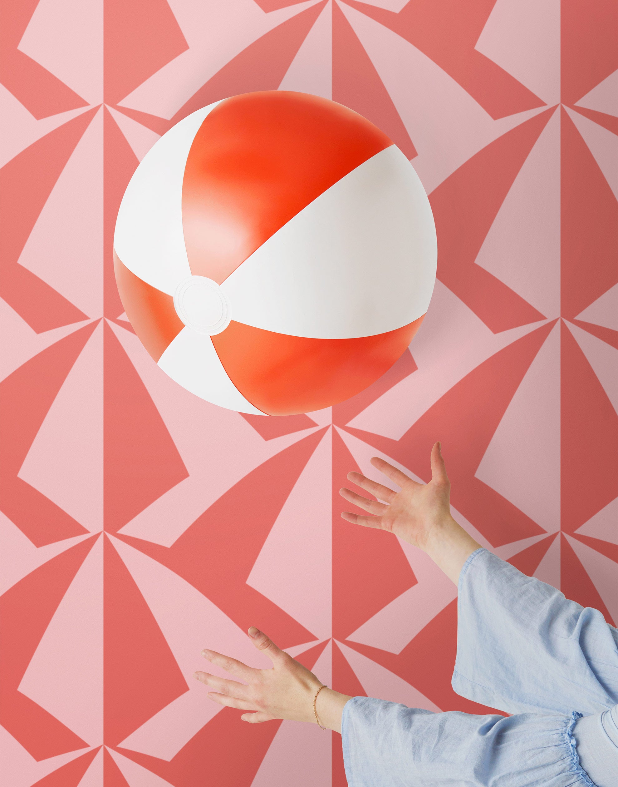 Parasol wallpaper is designed with overlapping shapes of multicolored beach umbrellas. Highly durable, fade resistant, and made in the USA. This wallpaper has a coral print on a pink background and is designed in collaboration with The Aesthetics of Joy.