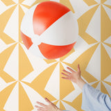 Parasol wallpaper is designed with overlapping shapes of multicolored beach umbrellas. Highly durable, fade resistant, and made in the USA. This wallpaper has a yellow print on white background and is designed in collaboration with The Aesthetics of Joy.