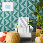 Parasol wallpaper is designed with overlapping shapes of multicolored beach umbrellas. Highly durable, fade resistant, and made in the USA. This wallpaper has a green print on a light blue background and is designed in collaboration with The Aesthetics of Joy.