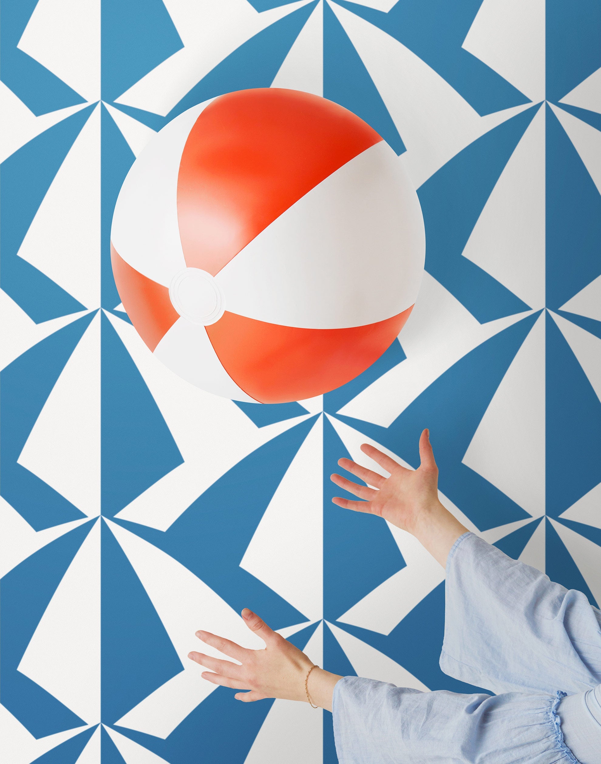 Parasol wallpaper is designed with overlapping shapes of multicolored beach umbrellas. Highly durable, fade resistant, and made in the USA. This wallpaper has a blue print on a white background and is designed in collaboration with The Aesthetics of Joy.