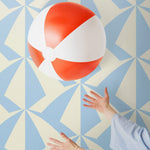 Parasol wallpaper is designed with overlapping shapes of multicolored beach umbrellas. Highly durable, fade resistant, and made in the USA. This wallpaper has a blue print on a cream background and is designed in collaboration with The Aesthetics of Joy.