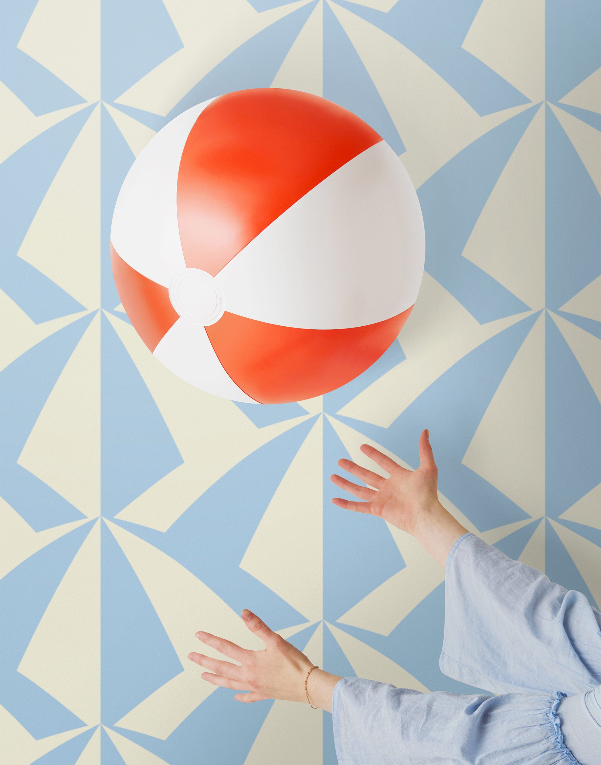 Parasol wallpaper is designed with overlapping shapes of multicolored beach umbrellas. Highly durable, fade resistant, and made in the USA. This wallpaper has a blue print on a cream background and is designed in collaboration with The Aesthetics of Joy.