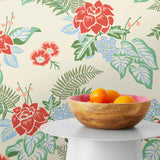 Our Lanai wallpaper is inspired by the rich tradition and exuberant patterns of Hawaiian shirts, with a twist. Highly durable, fade resistant, and made in the USA. This wallpaper features red flowers with green and blue leaves on a cream background and was created in collaboration with The Aesthetics of Joy.