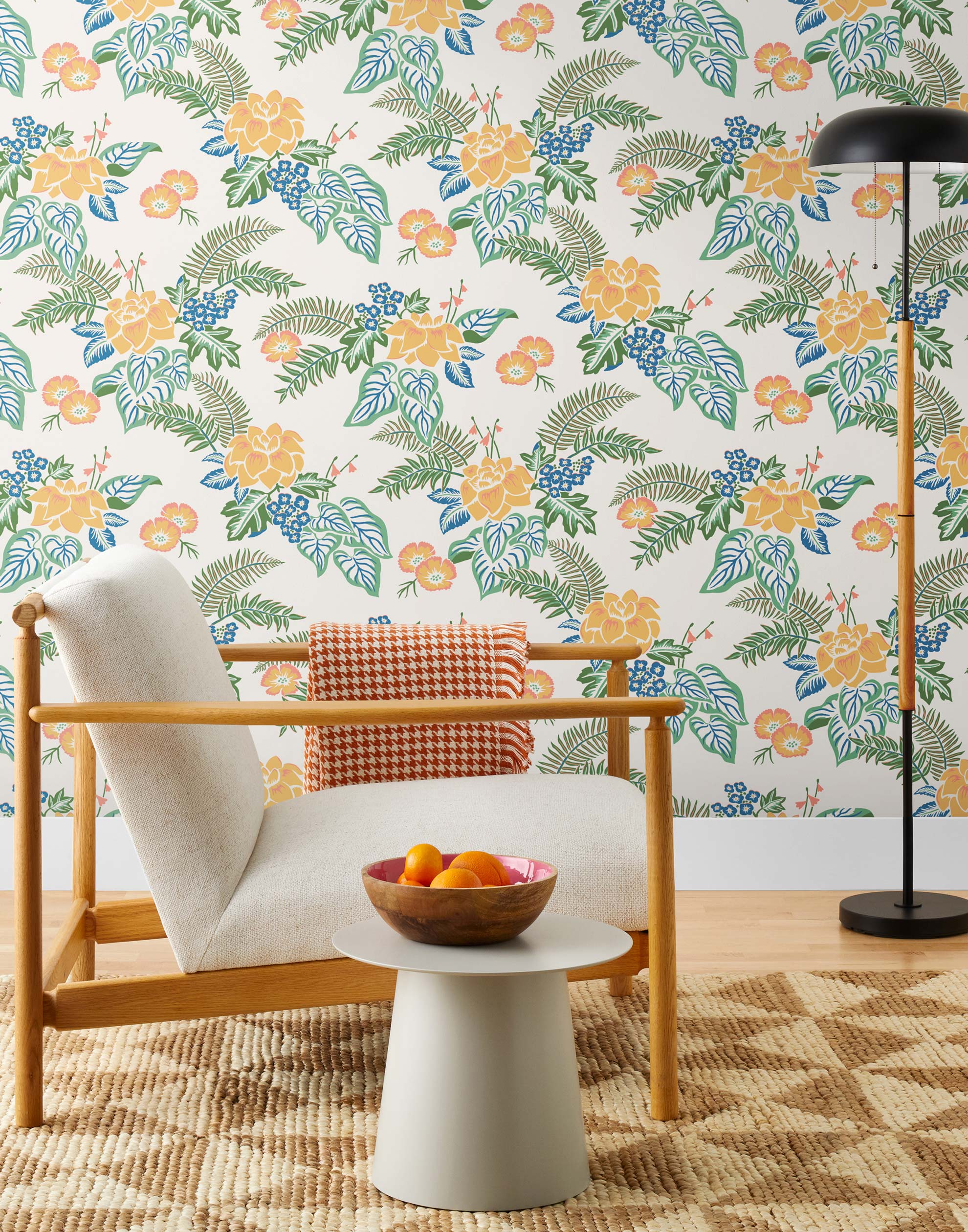 Our Lanai wallpaper is inspired by the rich tradition and exuberant patterns of Hawaiian shirts, with a twist. Highly durable, fade resistant, and made in the USA. This wallpaper features yellow flowers with green and blue leaves on a white background and was created in collaboration with The Aesthetics of Joy.