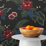 Our Lanai wallpaper is inspired by the rich tradition and exuberant patterns of Hawaiian shirts, with a twist. Highly durable, fade resistant, and made in the USA. This wallpaper features red flowers with green and blue leaves on a black background and was created in collaboration with The Aesthetics of Joy.