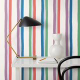 Our Picnic wallpaper was inspired by the wavy stripes of a picnic blanket. Highly durable, fade resistant, and made in the USA. This wallpaper has green, blue, red and purple stripes on a white background and was made in collaboration with The Aesthetics of Joy.