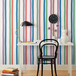 Our Picnic wallpaper was inspired by the wavy stripes of a picnic blanket. Highly durable, fade resistant, and made in the USA. This wallpaper has green, blue, red and purple stripes on a white background and was made in collaboration with The Aesthetics of Joy.