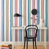 Our Picnic wallpaper was inspired by the wavy stripes of a picnic blanket. Highly durable, fade resistant, and made in the USA. This wallpaper has green, blue, red and purple stripes on a white background and was made in collaboration with The Aesthetics of Joy.