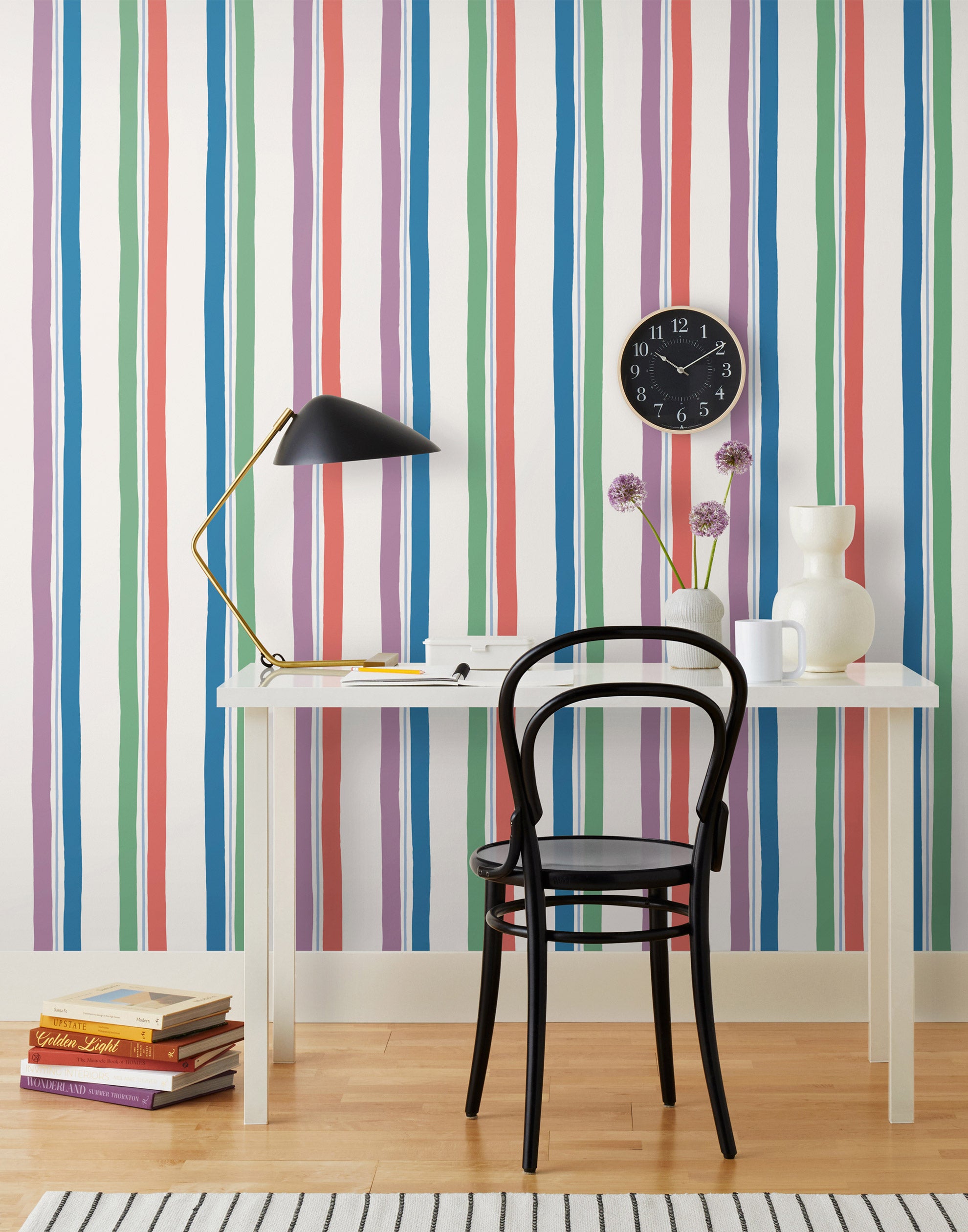 Our Picnic wallpaper was inspired by the wavy stripes of a picnic blanket. Highly durable, fade resistant, and made in the USA. This wallpaper has green, blue, red and purple stripes on a white background and was made in collaboration with The Aesthetics of Joy.