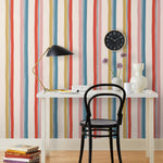 Our Picnic wallpaper was inspired by the wavy stripes of a picnic blanket. Highly durable, fade resistant, and made in the USA. This wallpaper has  blue, red , mustard yellow, and pink stripes on a blush background and was made in collaboration with The Aesthetics of Joy.