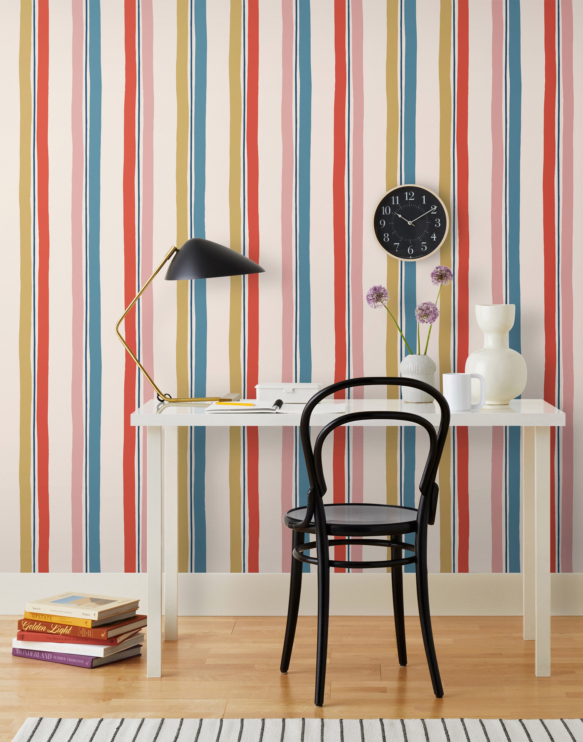 Our Picnic wallpaper was inspired by the wavy stripes of a picnic blanket. Highly durable, fade resistant, and made in the USA. This wallpaper has  blue, red , mustard yellow, and pink stripes on a blush background and was made in collaboration with The Aesthetics of Joy.