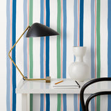 Our Picnic wallpaper was inspired by the wavy stripes of a picnic blanket. Highly durable, fade resistant, and made in the USA. This wallpaper has blue and green stripes on a white background and was made in collaboration with The Aesthetics of Joy.