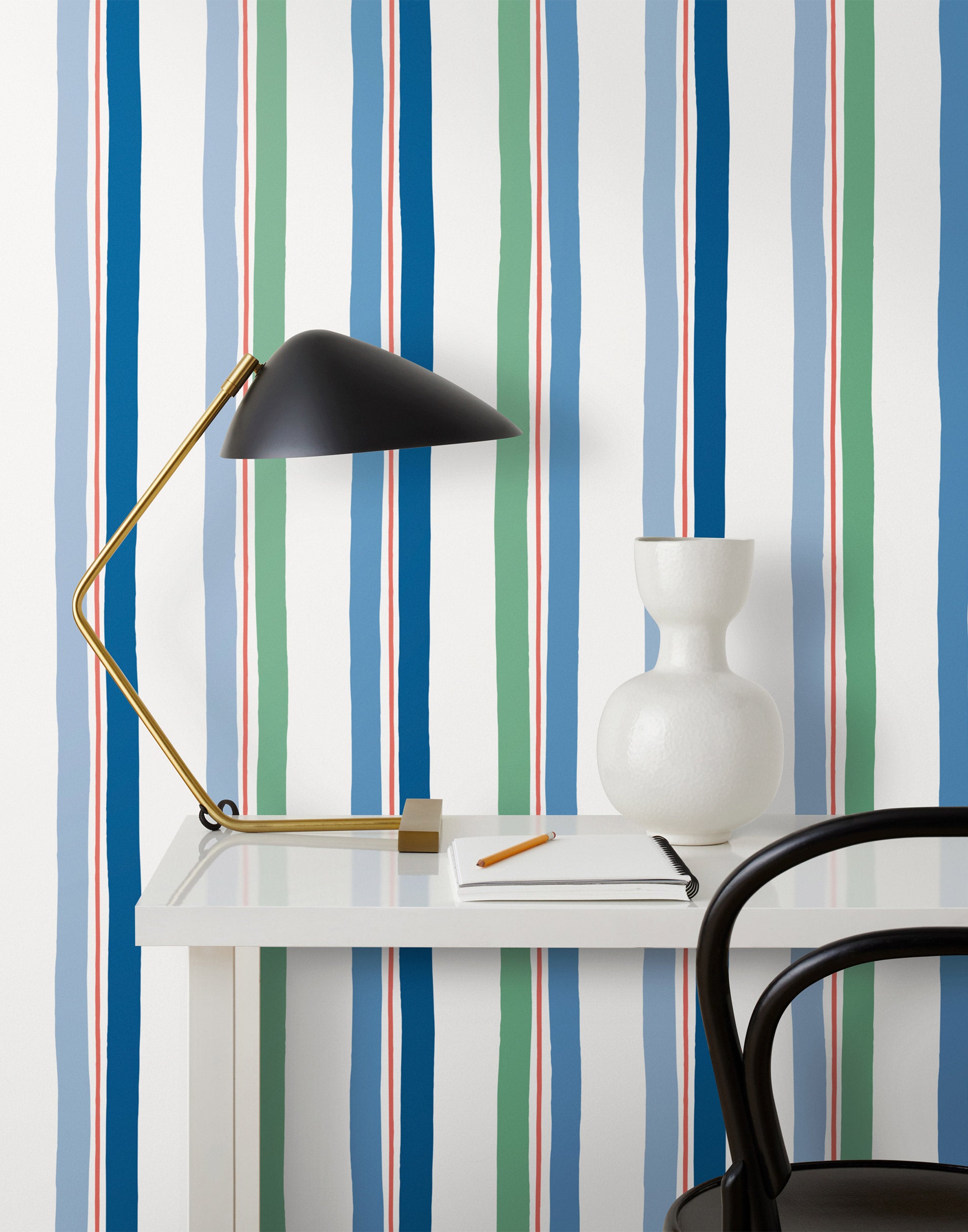 Our Picnic wallpaper was inspired by the wavy stripes of a picnic blanket. Highly durable, fade resistant, and made in the USA. This wallpaper has blue and green stripes on a white background and was made in collaboration with The Aesthetics of Joy.