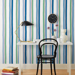 Our Picnic wallpaper was inspired by the wavy stripes of a picnic blanket. Highly durable, fade resistant, and made in the USA. This wallpaper has blue and green stripes on a white background and was made in collaboration with The Aesthetics of Joy.