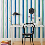 Our Picnic wallpaper was inspired by the wavy stripes of a picnic blanket. Highly durable, fade resistant, and made in the USA. This wallpaper has blue and green stripes on a white background and was made in collaboration with The Aesthetics of Joy.