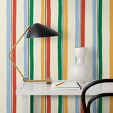 Our Picnic wallpaper was inspired by the wavy stripes of a picnic blanket. Highly durable, fade resistant, and made in the USA. This wallpaper has green, blue, red and yellow stripes on a cream background and was made in collaboration with The Aesthetics of Joy.
