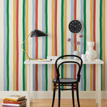 Our Picnic wallpaper was inspired by the wavy stripes of a picnic blanket. Highly durable, fade resistant, and made in the USA. This wallpaper has green, blue, red and yellow stripes on a cream background and was made in collaboration with The Aesthetics of Joy.