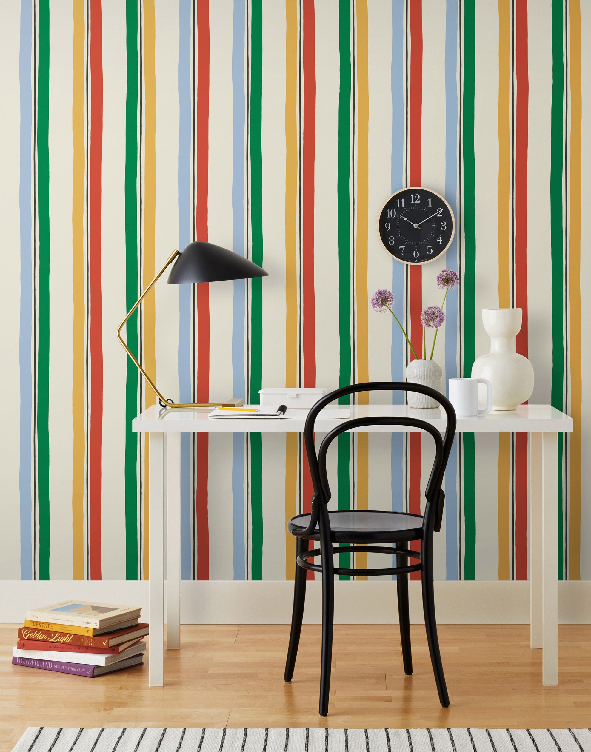 Our Picnic wallpaper was inspired by the wavy stripes of a picnic blanket. Highly durable, fade resistant, and made in the USA. This wallpaper has green, blue, red and yellow stripes on a cream background and was made in collaboration with The Aesthetics of Joy.