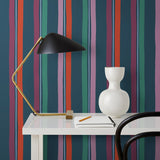Our Picnic wallpaper was inspired by the wavy stripes of a picnic blanket. Highly durable, fade resistant, and made in the USA. This wallpaper has red, purple, lilac and green stripes on a navy blue background and was made in collaboration with The Aesthetics of Joy.