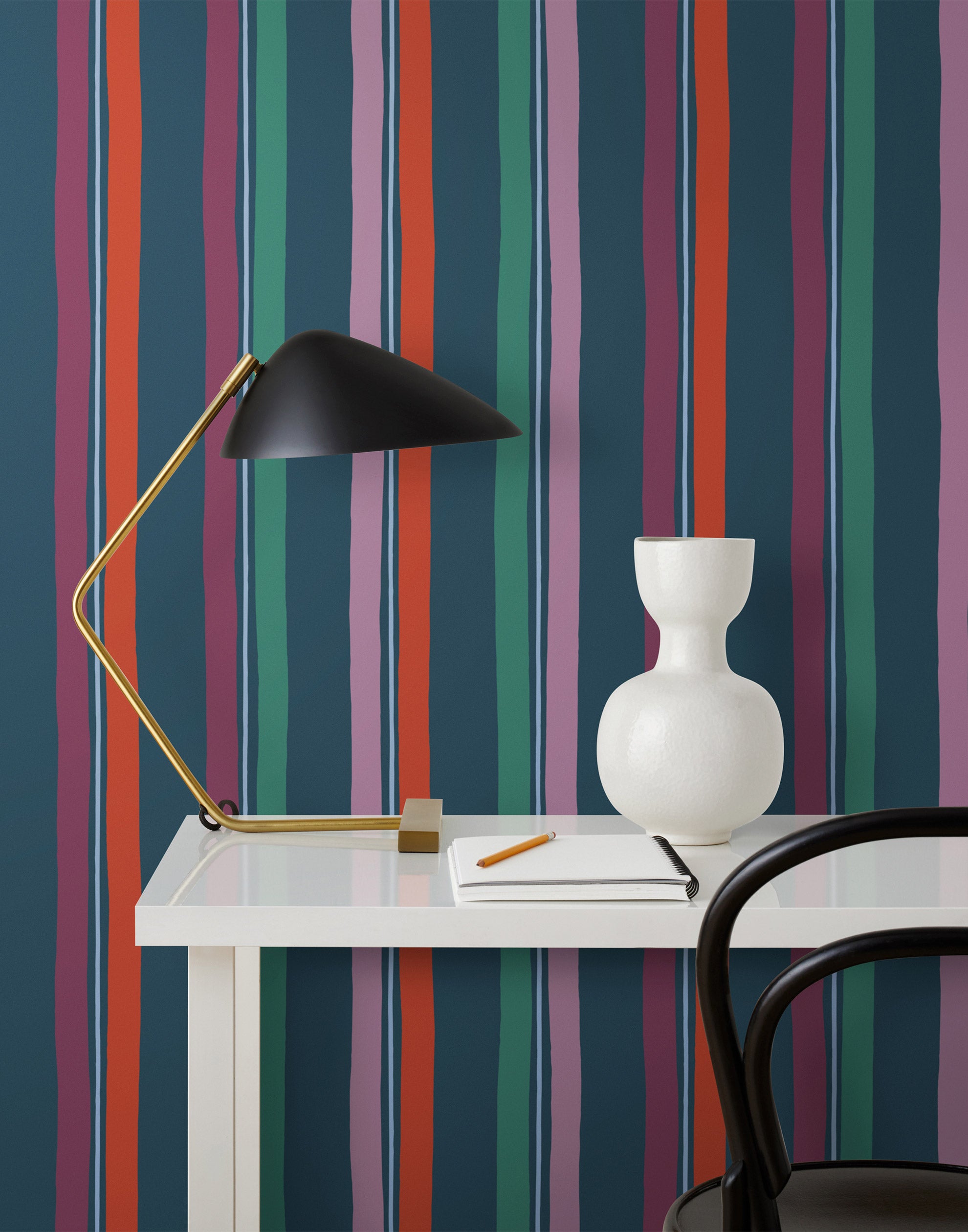 Our Picnic wallpaper was inspired by the wavy stripes of a picnic blanket. Highly durable, fade resistant, and made in the USA. This wallpaper has red, purple, lilac and green stripes on a navy blue background and was made in collaboration with The Aesthetics of Joy.