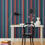 Our Picnic wallpaper was inspired by the wavy stripes of a picnic blanket. Highly durable, fade resistant, and made in the USA. This wallpaper has red, purple, lilac and green stripes on a navy blue background and was made in collaboration with The Aesthetics of Joy.