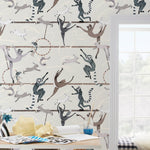Balancing Act (Cream) wallpaper features colorful dancing monkeys and rabbits on a cream background