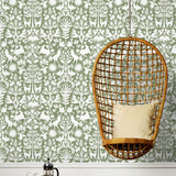 Folklore (Fern) features white animals and flowers in a mirroring pattern on a soft green backgroud designed by Emily Isabella for Hygge & West
