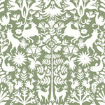 Folklore (Fern) features white animals and flowers in a mirroring pattern on a soft green backgroud designed by Emily Isabella for Hygge & West