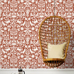 Folklore (Terracotta) features white animals and flowers in a mirroring pattern on a terracotta red backgroud designed by Emily Isabella for Hygge & West