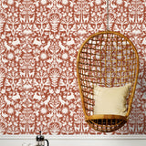 Folklore (Terracotta) features white animals and flowers in a mirroring pattern on a terracotta red backgroud designed by Emily Isabella for Hygge & West