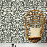 Folklore (Sage) features white animals and flowers in a mirroring pattern on a sage green backgroud designed by Emily Isabella for Hygge & West