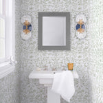 Storyline (Sage) Wallpaper | Folk art inspired pattern featuring flora and fauna in sage green on a soft gray ground