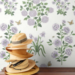 This large-scale wallpaper features hand drawn bees, butterflies and other garden friends frolic among flowers - camellias, hellebores, irises, and snowball trees. Harmony (Ebony) is printed in shades of green and purple on a white background.