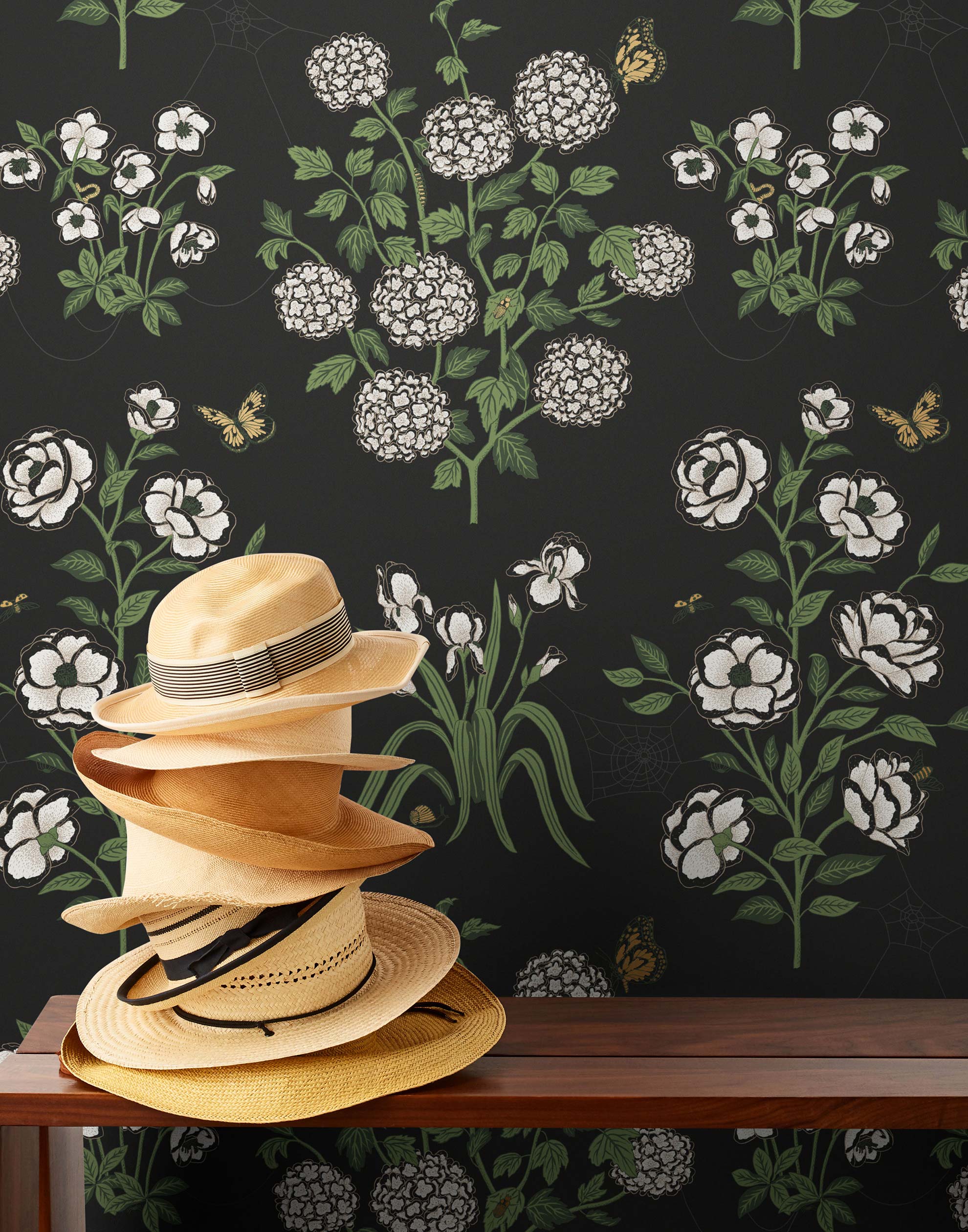 This large-scale wallpaper features hand drawn bees, butterflies and other garden friends frolic among flowers - camellias, hellebores, irises, and snowball trees. Harmony (Ebony) is printed in shades of green and white on a black background.