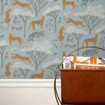 Our Serengeti wallpaper features brown cheetahs and birds scattered among white acacia trees on a dusty blue background, reflecting the powerful beauty of the vast plains. Designed by Julia Rothman and made in the USA.
