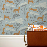 Our Serengeti wallpaper features brown cheetahs and birds scattered among white acacia trees on a dusty blue background, reflecting the powerful beauty of the vast plains. Designed by Julia Rothman and made in the USA.