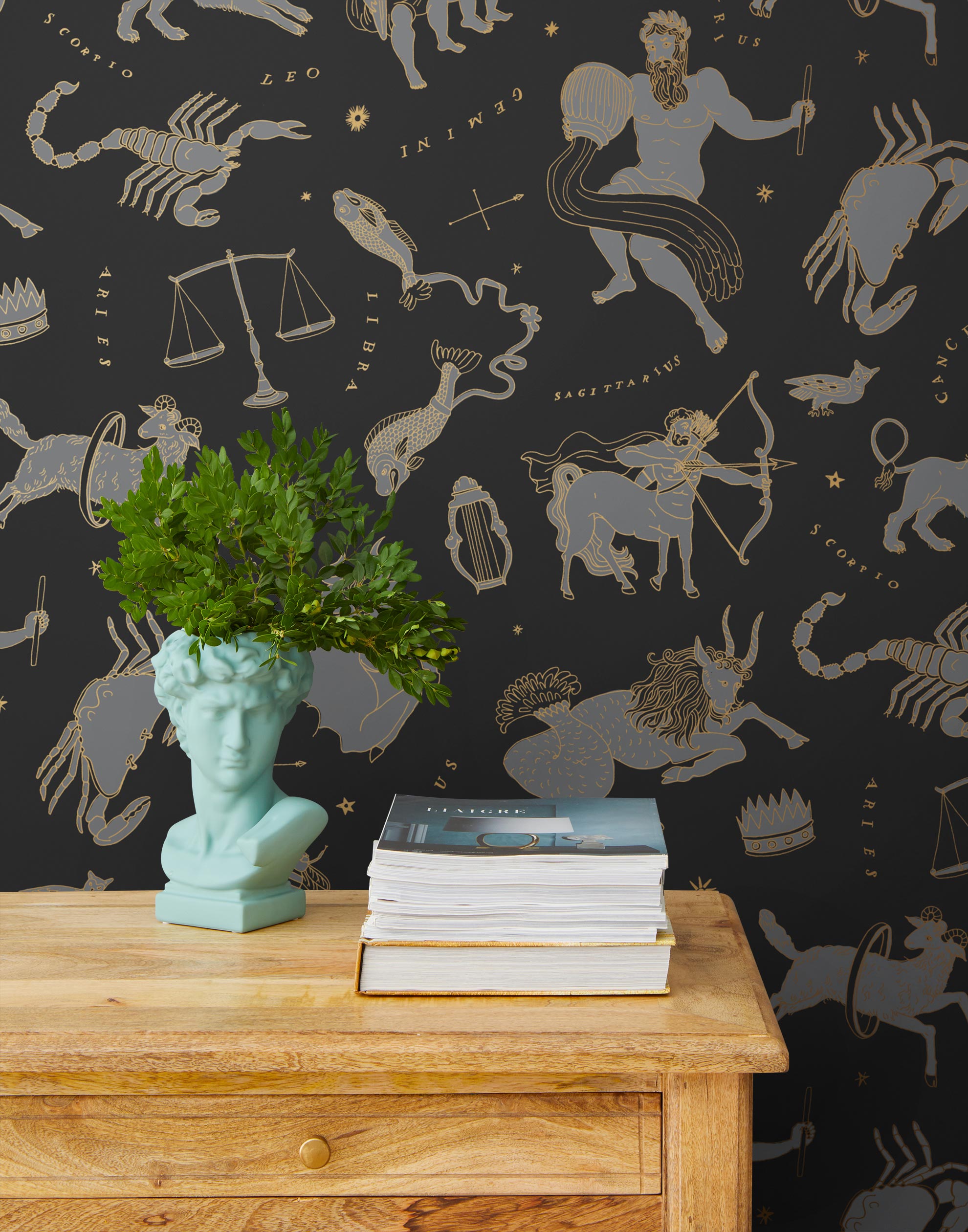 Our In the Stars wallpaper is inspired by Urania’s Mirror, a 19th-century set of astrology charts. This hand-drawn pattern evokes the mysterious motion of celestial bodies. This wallpaper features gray and gold motifs on a black background and was designed by Julia Rothman.