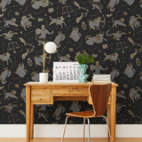 Our In the Stars wallpaper is inspired by Urania’s Mirror, a 19th-century set of astrology charts. This hand-drawn pattern evokes the mysterious motion of celestial bodies. This wallpaper features gray and gold motifs on a black background and was designed by Julia Rothman.