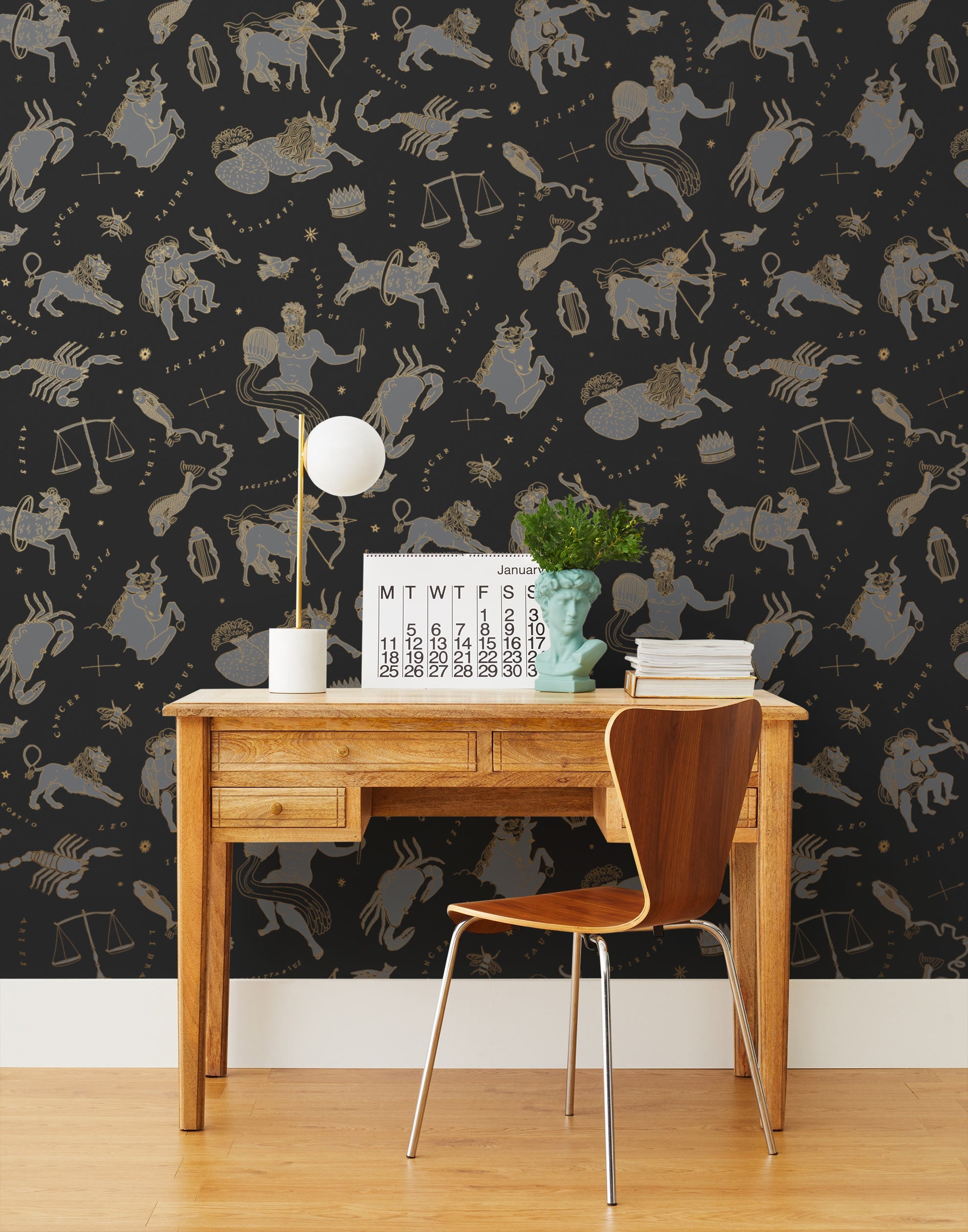 Our In the Stars wallpaper is inspired by Urania’s Mirror, a 19th-century set of astrology charts. This hand-drawn pattern evokes the mysterious motion of celestial bodies. This wallpaper features gray and gold motifs on a black background and was designed by Julia Rothman.