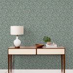 Olive Grove (Mist) featuring a leafy vine motif in shades of green with copper accents on dusty blue background | Schoolhouse x Hygge & West Wallpaper Collection