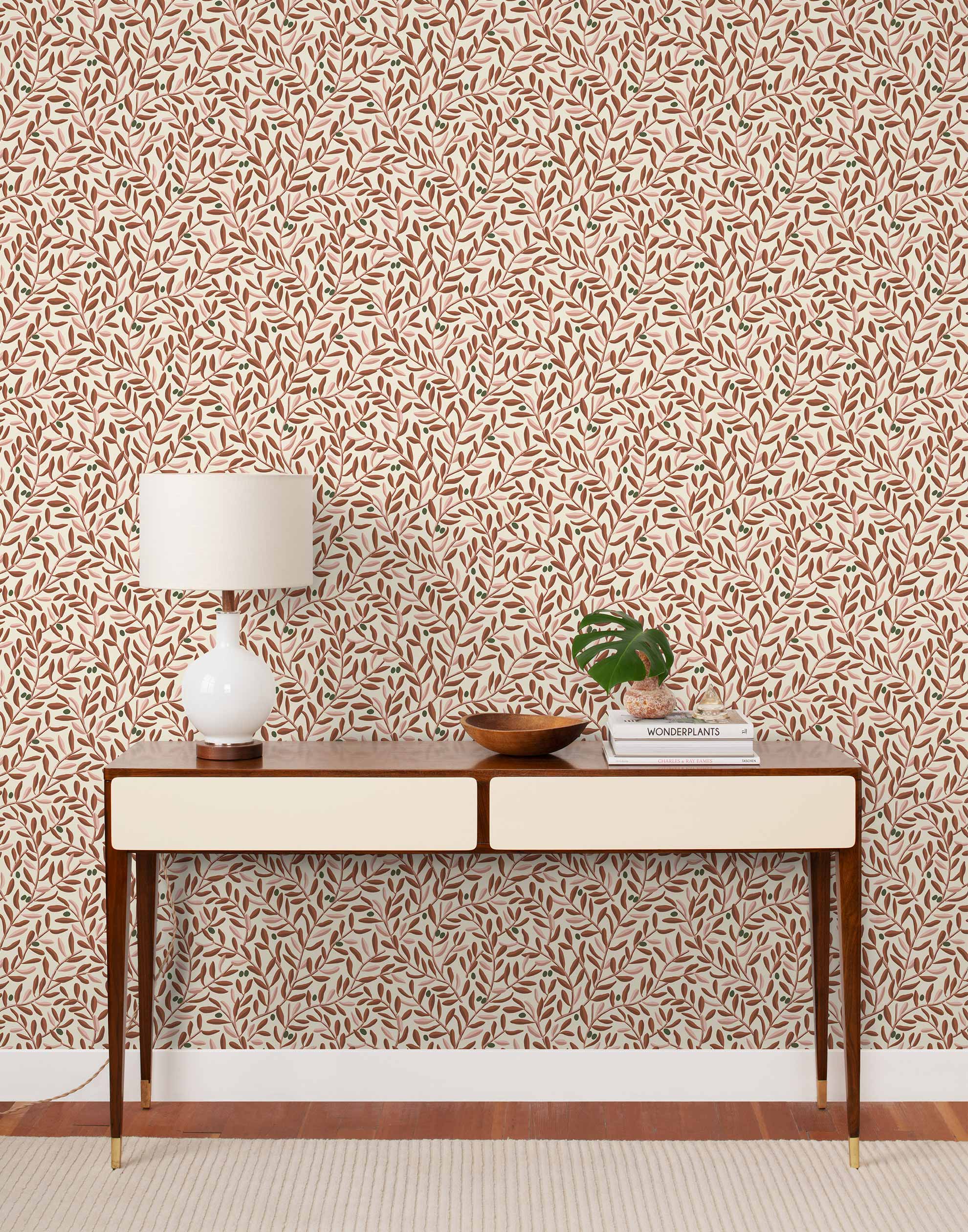 Olive Grove (Bellini) featuring a leafy vine motif in shades of rust and pink with green accents on an off white background | Schoolhouse x Hygge & West Wallpaper Collection