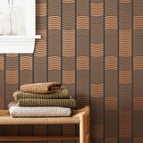 Wallpaper with undulating copper lines that form rhythmic columns on a dark gray background | Schoolhouse + Hygge & West