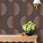 Wallpaper with irregular line work that weaves copper rectangles and pink semicircles on a deep gray background | Schoolhouse + Hygge & West
