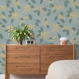 Wallpaper with yellow acacia flowers and green leaves on a dusty blue background | Schoolhouse + Hygge & West