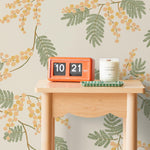 Wallpaper with coral and pink acacia flowers and green leaves on a cream background | Schoolhouse + Hygge & West