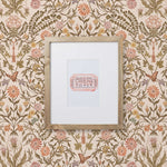 Inspired by the painted ceiling of Glinda and Elphaba's Shiz University dorm room in the movie Wicked, this wallpaper features colorful flowers and a crown on a soft pink background.