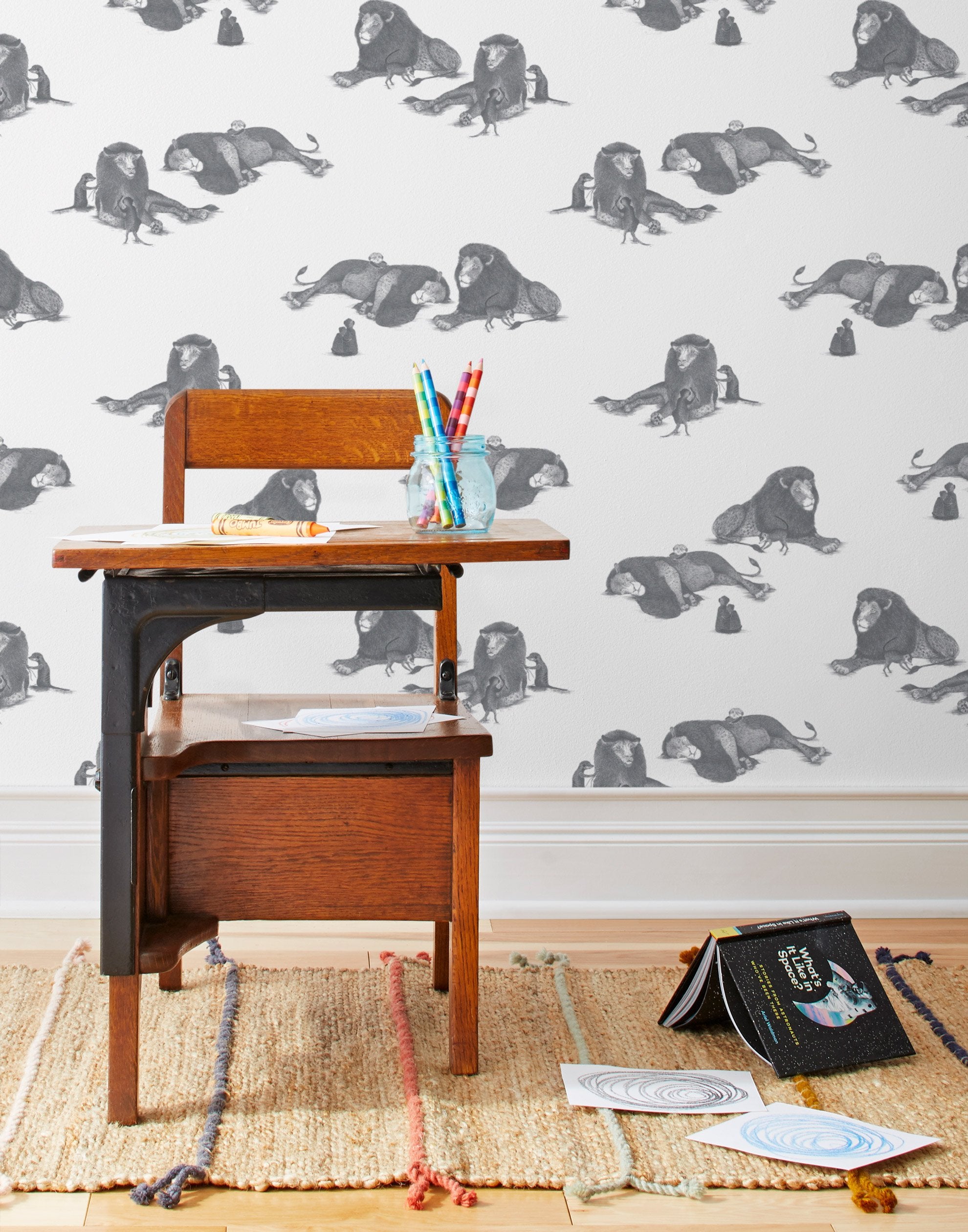 Mighty (Charcoal) wallpaper features gray lions and meerkats on a white background