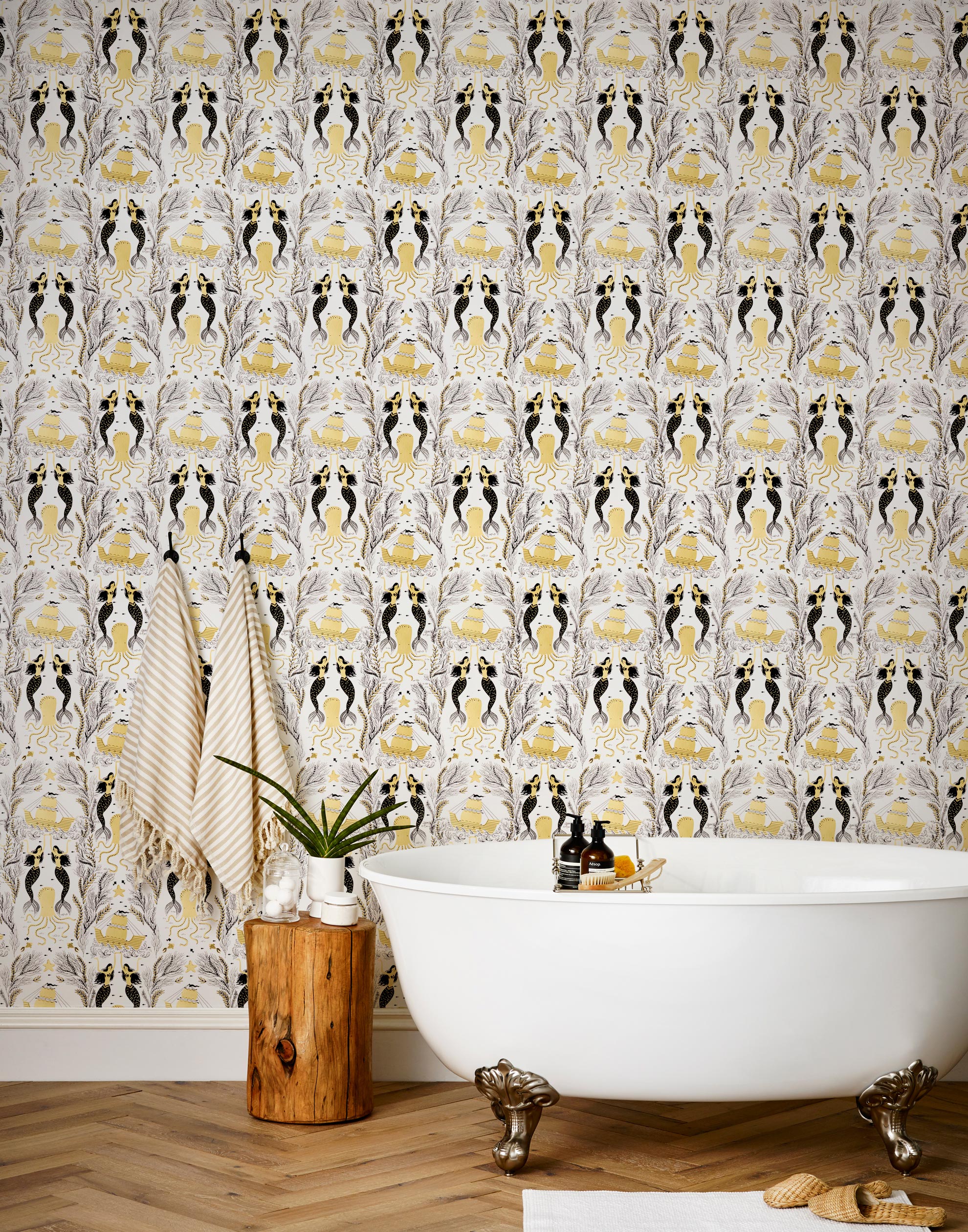 Mermaids (Gold) wallpaper | Mermaids, fish, octopi and ships float in this charming design | Gold and black artwork on an off white ground