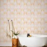 Mermaids (Shell Pink) wallpaper | Mermaids, fish, octopi and ships float in this charming design | Gold and white artwork on a pink ground