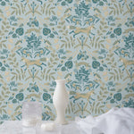 Piedmont (Mist) wallpaper with tan foxes, dusty deep green flora, cream accents on a light gray blue background